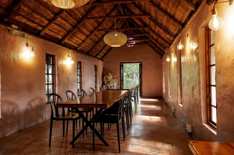 The Chapel's long dining table with black bentwood chairs and warm wall lights