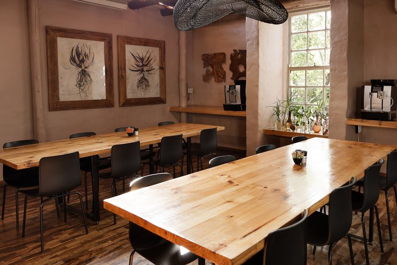 Oak Room tables seen at an angle, with framed botanical prints on the plaster wall