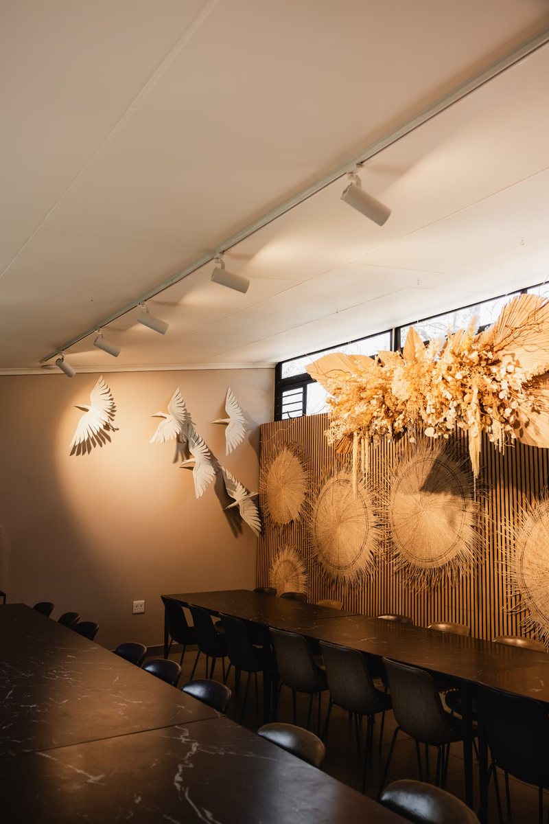 Sculpted white cranes in flight on the wall beside Still's slatted panel and dried floral installation