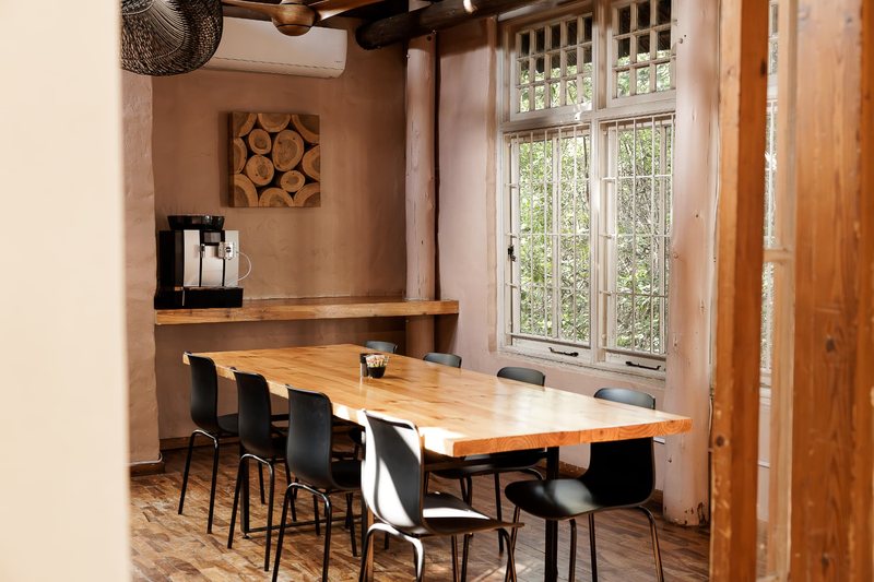 A single Oak Room table beside the tall paned window looking onto the garden