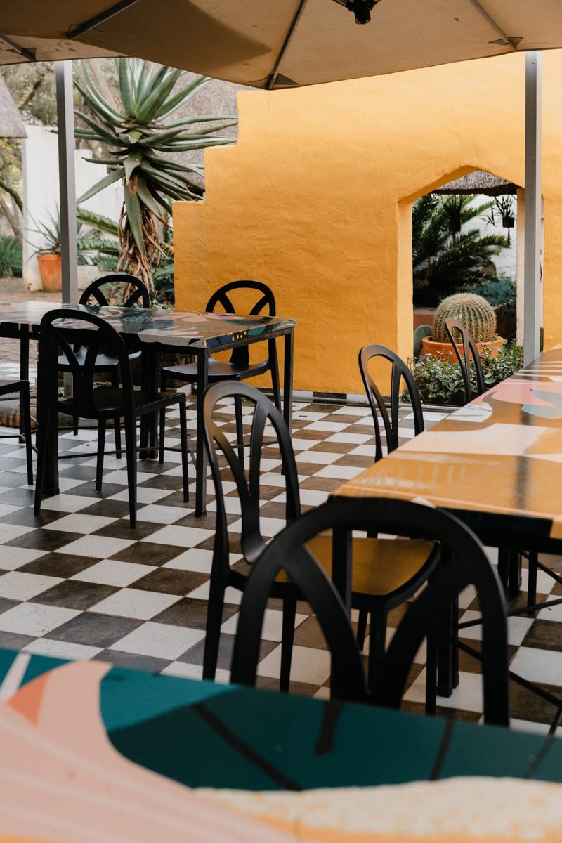 Courtyard seating beside the ochre wall with its arched opening and potted cactus