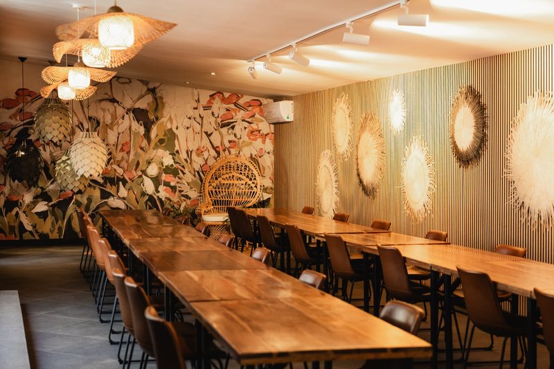 Bloot's slatted timber wall hung with woven discs, alongside long tables laid down the length of the room