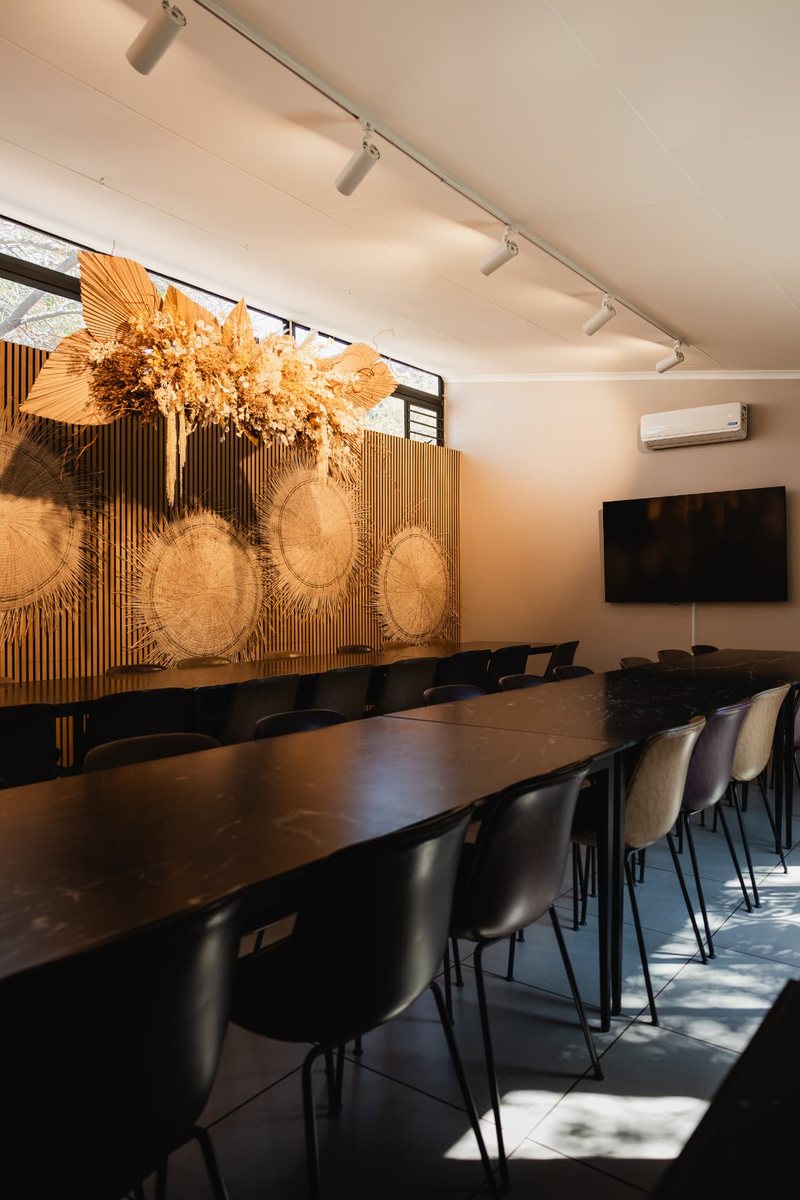 Still's marble tables running towards the slatted wall and dried floral cloud, with a wall-mounted screen alongside