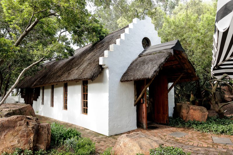 Whitewashed gable and thatched roof of the Chapel among the trees